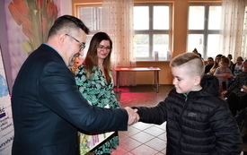 14. Dyrektor Ośrodka Kultury Sebastian Witkowski składający gratulację uczestnikowi konkursu